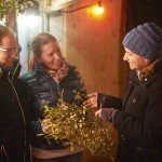 KIWANIS at the Christmas-Market in Erbach: Kiwanis past president Stephanie Uhrig selling mistletoe to customers at the Kiwani-booth, which is the garage of the church-caffe of the protestant church in Erbach.